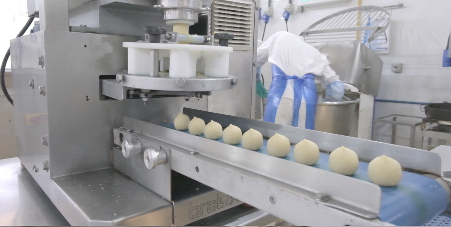 Dosadora depositando pães de queijo na esteira